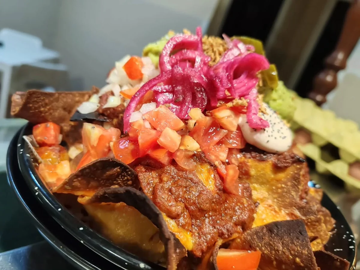 Sus nachos con chili, pico de gallo, guacamole y cebolla morada encurtida